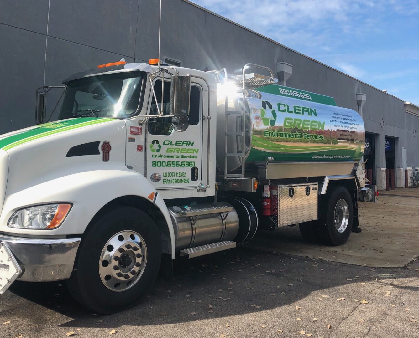 Green service truck with recycling logo.