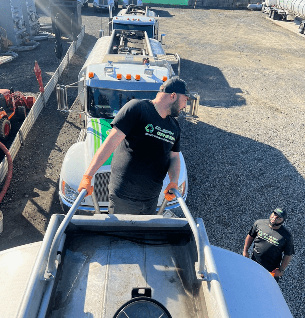 Workers cleaning or inspecting an industrial tank outdoors.