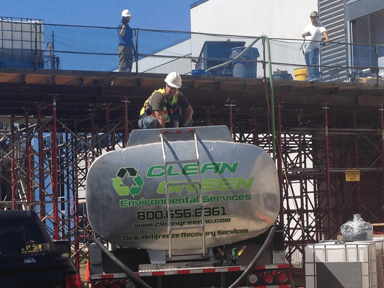 Construction workers on scaffolding and tanker