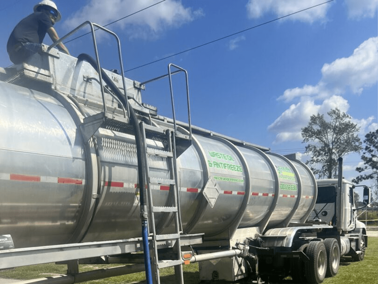 Industrial tanker truck on grassy area.